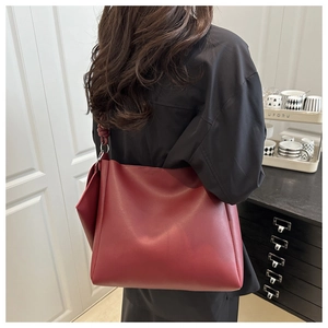 Dettaglio borsa tote bordeaux in pelle opaca con tracolla spessa e anello in metallo