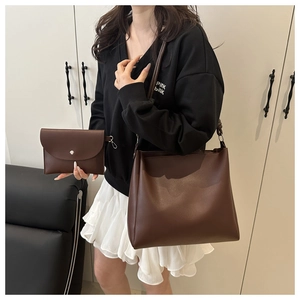 Dettaglio della borsa tote in pelle marrone con pochette a busta e tracolle sottili