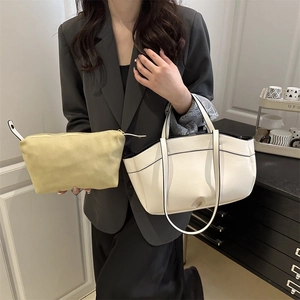 Chic white bucket tote bag with yellow pouch shown in a minimalist home setting
