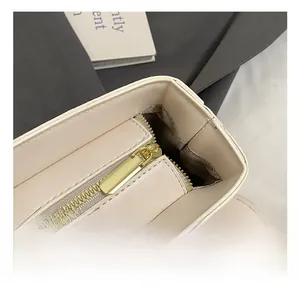 Close-up of premium cream leather bag with smooth gold-tone zipper hardware and stitching