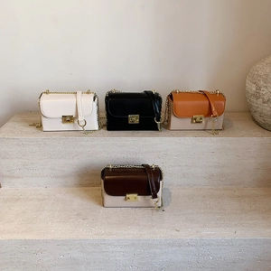 Modern small square flap bags with gold chains in four colors on stone display