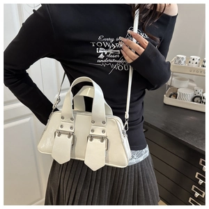 Detail der weißen glänzenden Trapezhandtasche mit Silberschnallen und Retro-Punk-Design