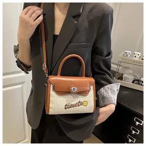 Fashionable canvas and brown leather crossbody bag styled on a grey suit outfit