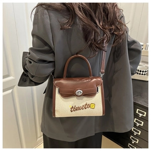 Detail of canvas leather crossbody bag with metal twist lock and embroidery