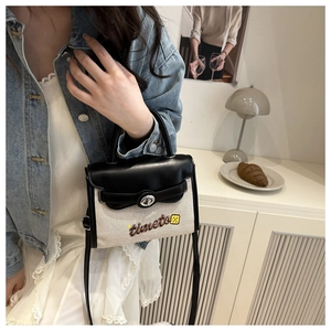 Detail of contrast color crossbody bag featuring timeto embroidery and silver lock