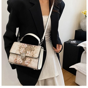 Borsa a tracolla alla moda con stampa serpente e fibbia a testa di leone su una modella