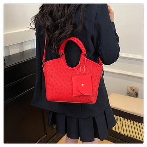 Detail of red leather bucket bag with black clover pattern and mini coin purse attachment