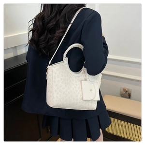 Detail of cream white monogram tote bag with matching coin purse and gold hardware