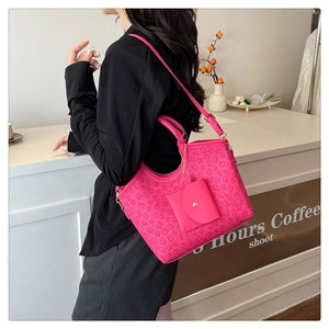 Detailed view of pink embossed tote bag with matching mini pouch and adjustable strap