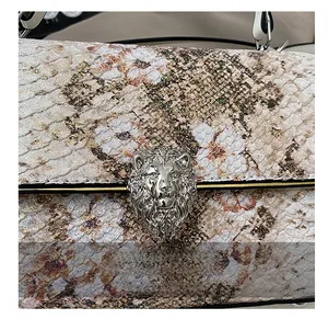 Dettaglio borsa con texture a serpente e fibbia magnetica a testa di leone argento
