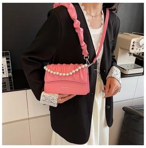 Close-up of pink ruched handbag featuring large pearl chain and Fashion & Bags embossing