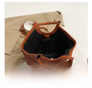Top view showing the spacious interior and embossed floral pattern of the caramel leather tote