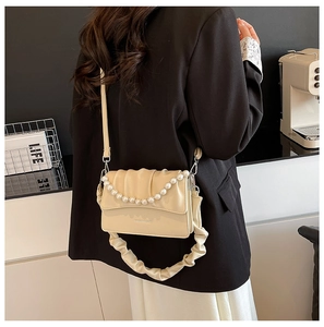Chic creamy yellow shoulder bag featuring pleated texture and elegant pearl chain detail