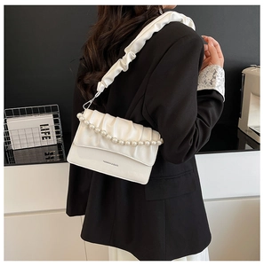Detail of white ruched shoulder bag with pearl chain and Fashion & Bags text on model