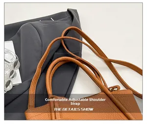 Detail of caramel brown pebble leather handbag with round handles and adjustable strap