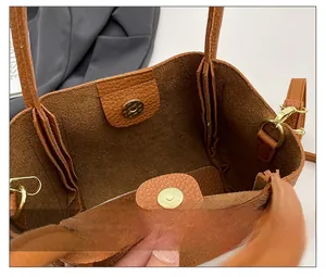 Detail shot of the golden magnetic closure and pebbled leather interior of a bucket bag