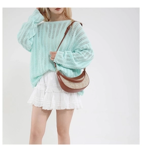 Crescent straw shoulder bag with brown leather trim paired with a knit mint top