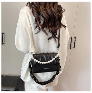 Detail of ruched black leather shoulder bag with large pearl chain and silver hardware