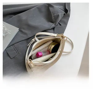 Top view of the spacious inner compartment of the cream-colored crescent bag with daily items