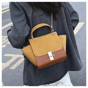 Detail of vintage patchwork crossbody bag with mustard suede and croc texture leather