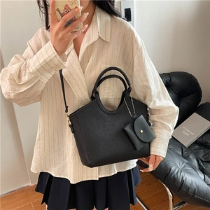 Modern black embossed tote bag with dual handles and mini coin purse accessory
