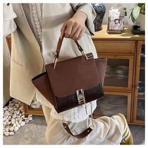 Detail of vintage tote bag with frosted patchwork and gold metal lock on handle