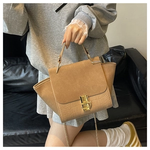 Detail of khaki wings bag featuring crocodile embossed leather and gold lock buckle