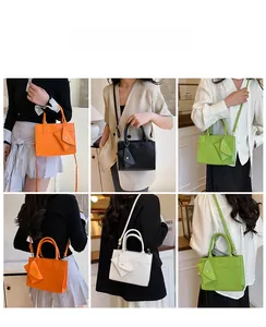 Détail du sac bandoulière tendance avec sangle amovible et petit accessoire pochette triangle
