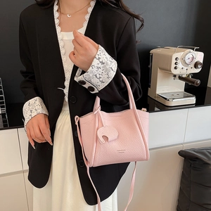 Pink lychee grain leather bucket bag with elephant charm and detachable shoulder strap