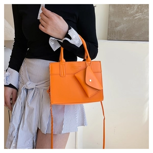 Détail du sac en similicuir orange vif avec pochette amovible et inscription mode