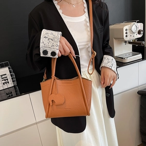 Brown soft leather bucket bag with cute elephant charm and adjustable shoulder strap