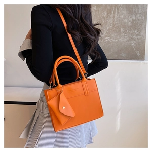 Détail du sac cabas orange vif avec petite pochette assortie et bandoulière longue