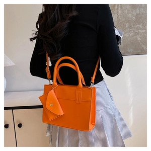 Sac fourre-tout orange avec porte-monnaie triangle porté en bandoulière par un mannequin