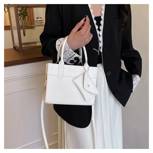 Vue détaillée du sac cabas en cuir blanc avec petite pochette enveloppe et ferrures dorées