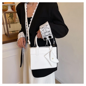 Détail d'un sac à bandoulière en cuir blanc avec un petit porte-monnaie amovible attaché