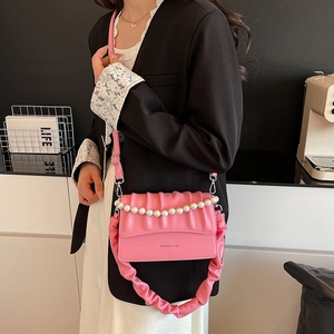 Pink pleated crossbody bag with pearl chain and fashion lettering on minimalist background
