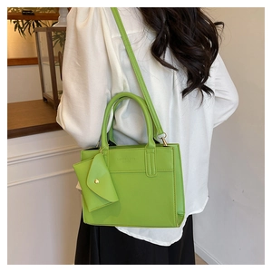 Détail du sac à main carré vert avec petite pochette assortie porté sur l'épaule