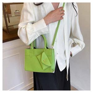 Détail d'un sac à main en cuir PU vert vif avec mini pochette assortie et logo embossé