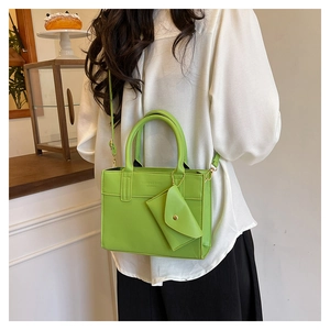 Détail du sac cabas vert vif en cuir PU avec mini porte-monnaie et logo embossé sur le devant