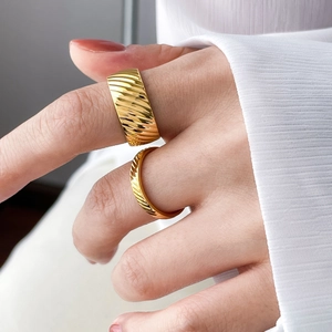 Close-up of dual set 18K gold-plated textured rings featuring elegant diagonal hammer patterns