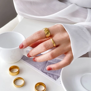 Detail of 18K gold-plated titanium steel rings featuring unique diagonal grooved textures
