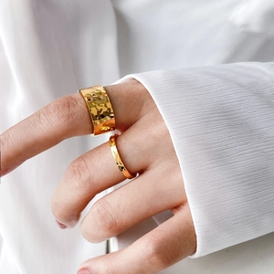 Detail of 18K gold plated titanium steel rings with hammered texture on model