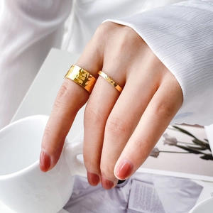 Detail of two hammered 18K gold plated titanium steel rings on model hand