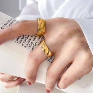 Detail of two 18K gold plated titanium steel rings with elegant diagonal ribbed texture