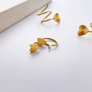 Détail d'une boucle d'oreille cœur doré avec placage d'or 18K et finition texturée radiale
