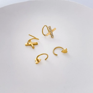 Détail de boucles d'oreilles en X plaquées or 18K et bagues d'oreille cœur avec cristaux