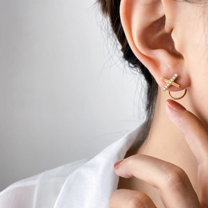 Boucles d'oreilles cœur en forme de X plaquées or 18 carats avec zircons sur mannequin