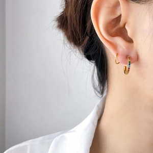 Boucles d'oreilles en X plaquées or 18 carats avec cristaux arc-en-ciel sur modèle