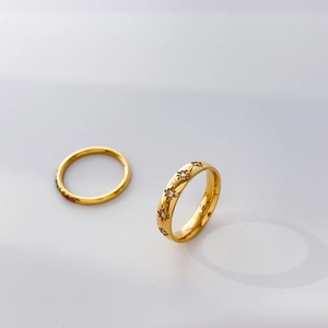 Detail of gold octagonal star rings with set crystals and colorful enamel accents