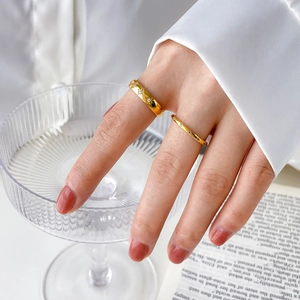 Gold wide band ring with star engraving and thin minimalist diamond band on finger